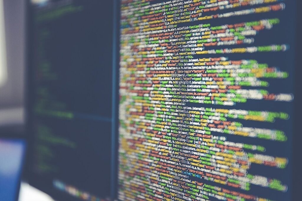 Écran d'ordinateur couvert de lignes de code colorées, vu de biais