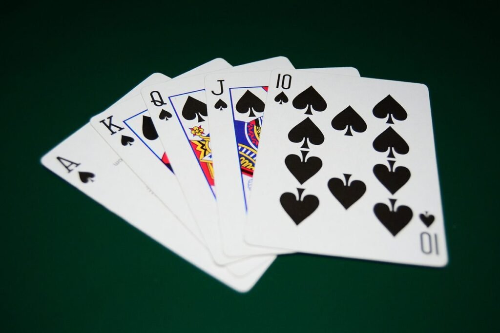 Quinte flush royale à pique étalée sur un tapis vert : As, Roi, Dame, Valet et 10