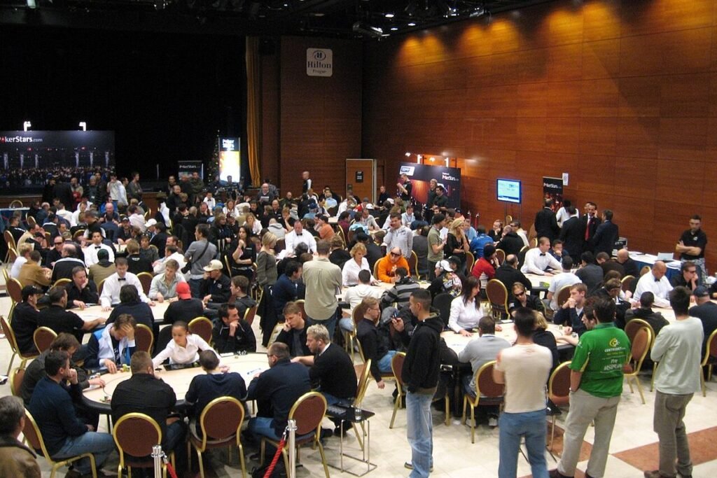 Grande salle de tournoi de poker remplie de tables rondes et de joueurs, lors d'une étape de l'European Poker Tour